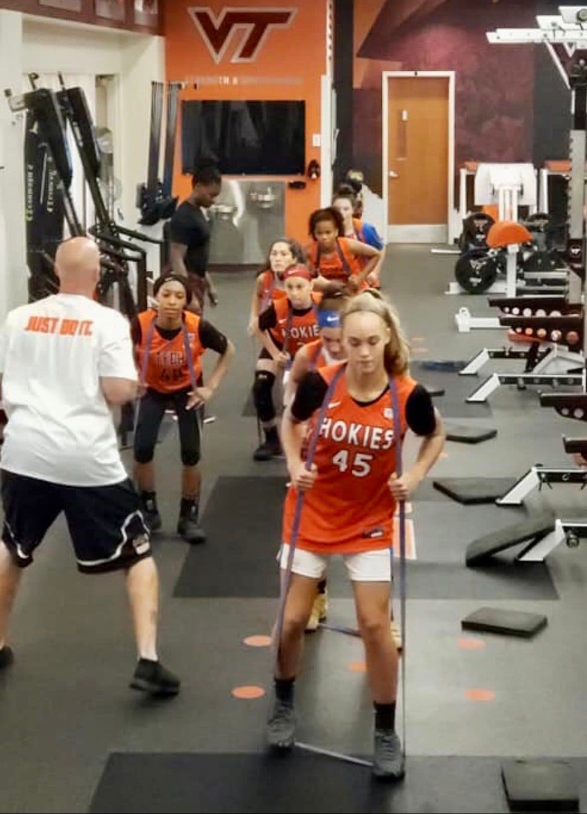 Coach Martens coaching a college women's basketball team through a resisted movement session