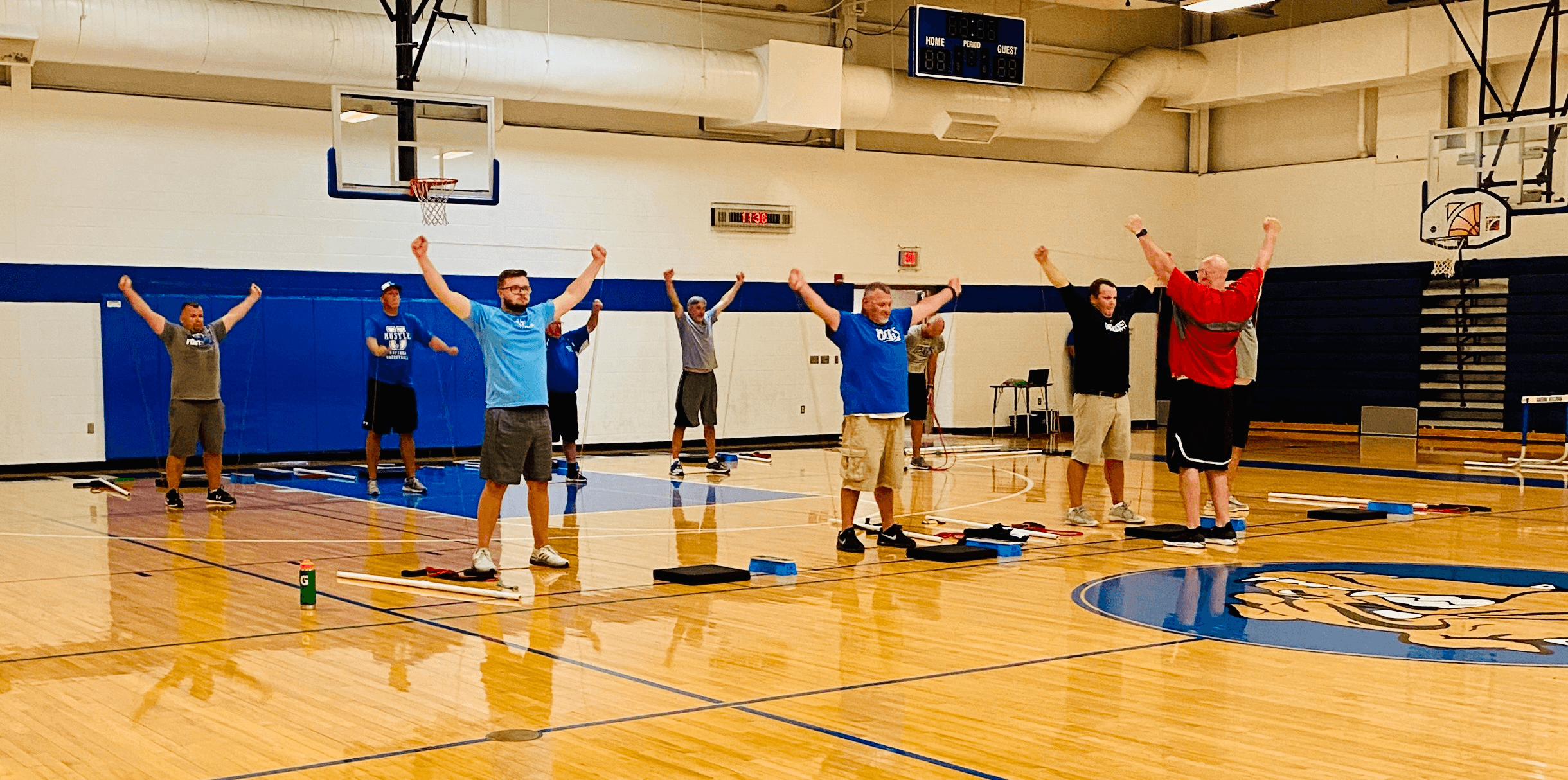 Coaches running through a movement session in a high school field house