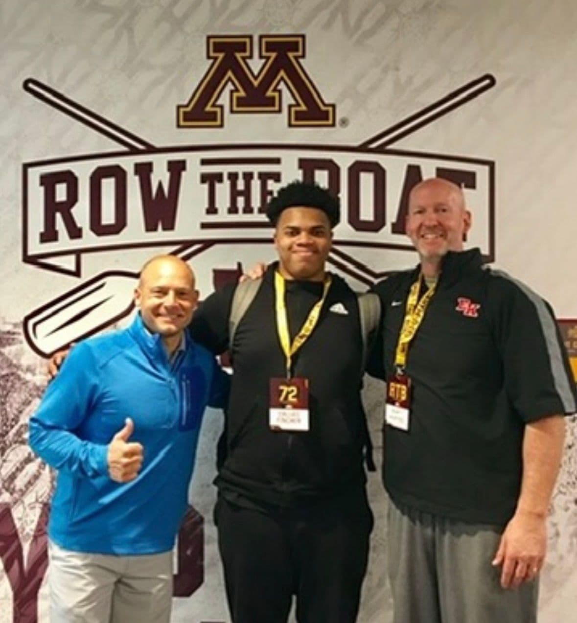Coach Martens with a recruit and a college coach at a Division I football facility