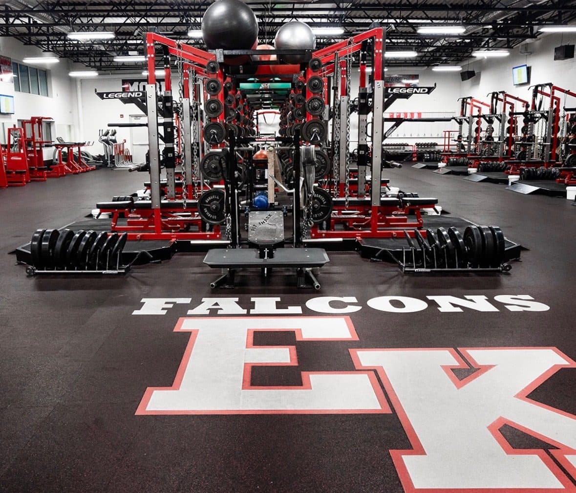 Racks and platforms around the Falcons logo on the East Kentwood weight room floor