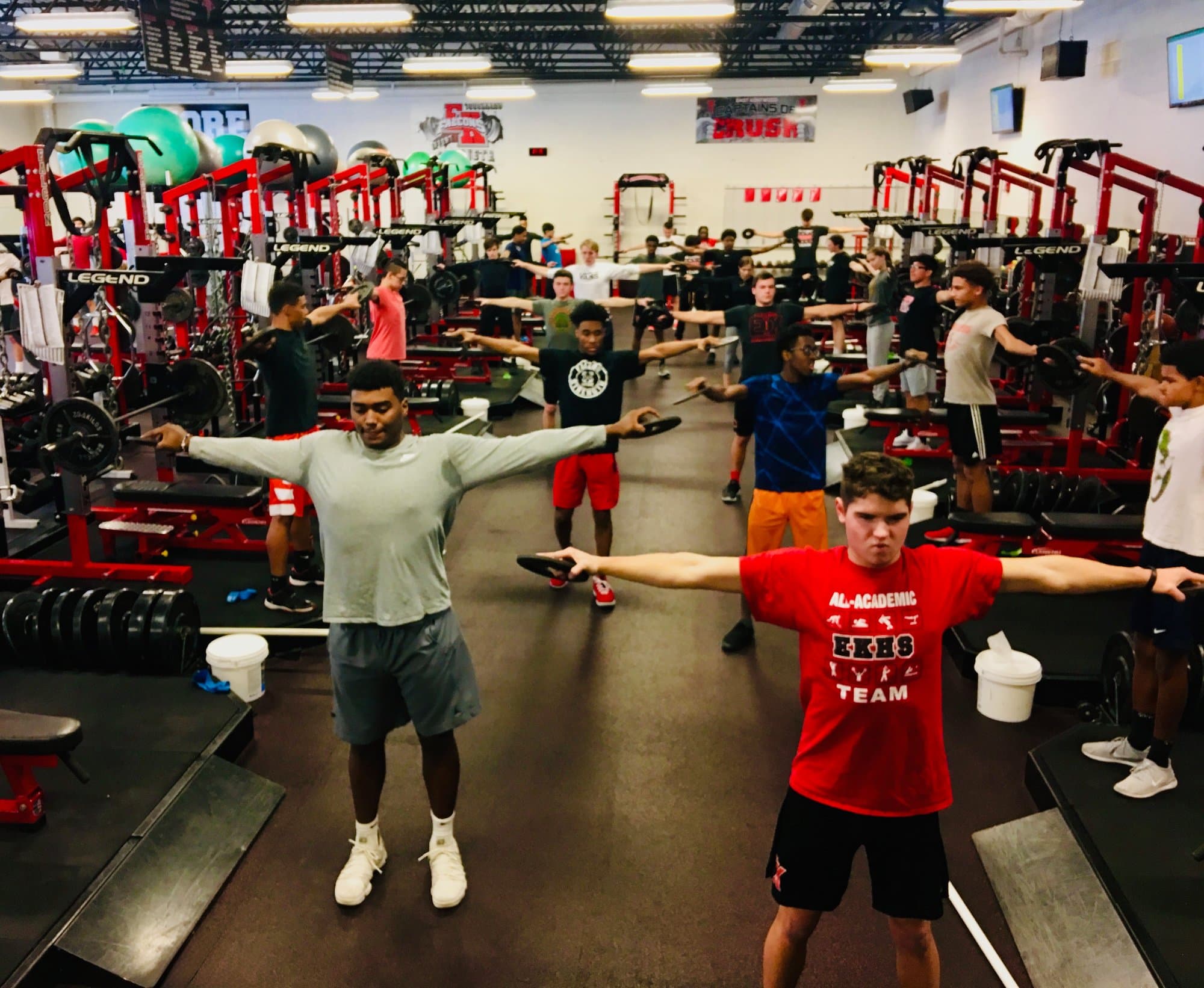 A full session in the East Kentwood weight room, every athlete working the same movement at the same time